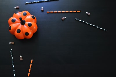 黑色桌子上的橙色和黑色圆点南瓜玩具